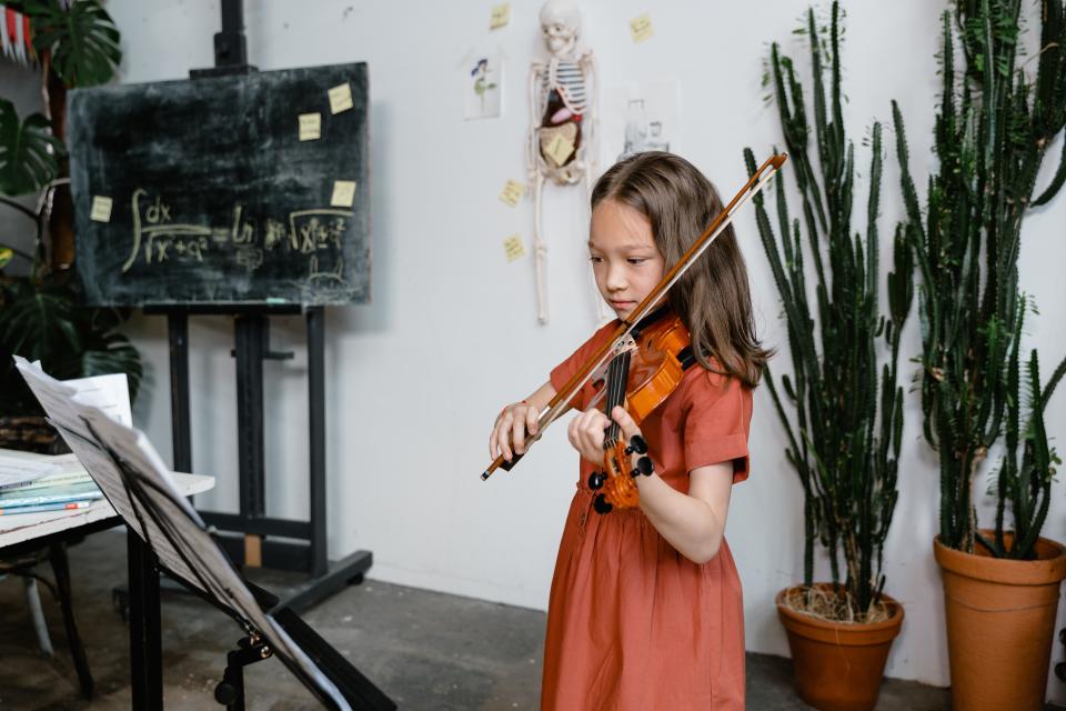 girl in orange dress plays violin