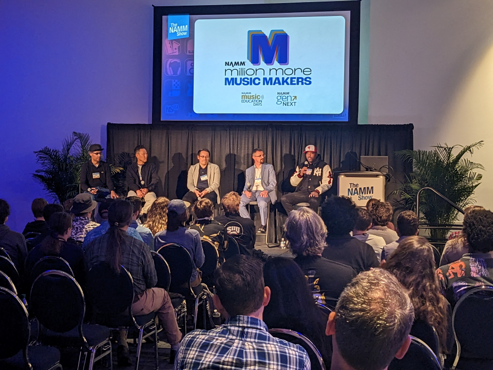 Attendees watch five person panel