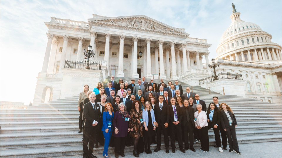 group of people standing on steps in front of the u.s. capitol building