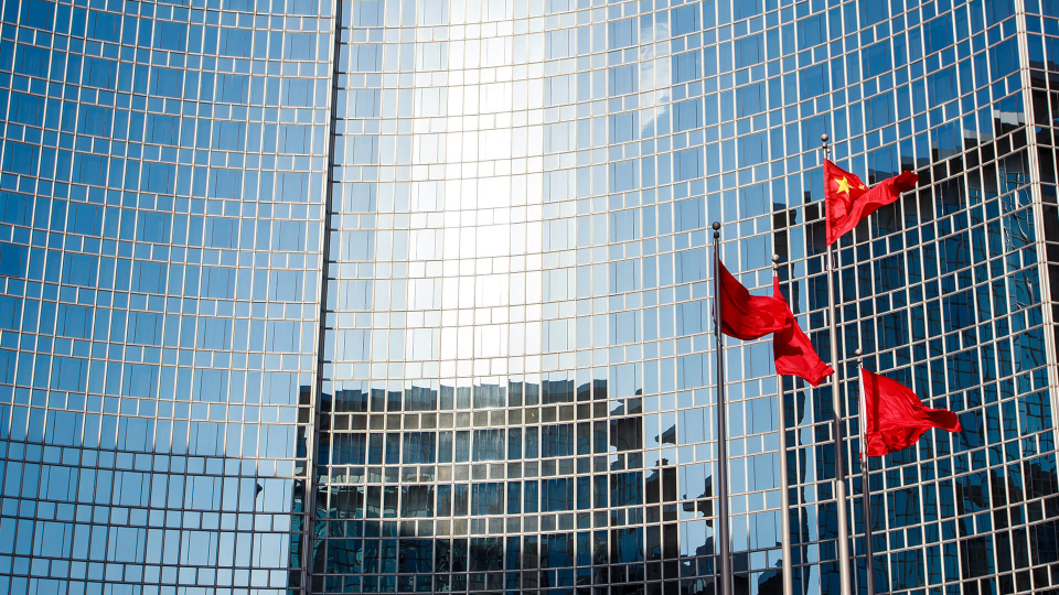 Chinese flags waving in front of building
