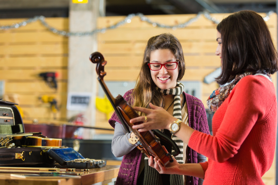 a music retail store employee assists customer