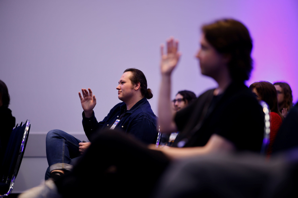 audience members raise their hands at entertainment technology session