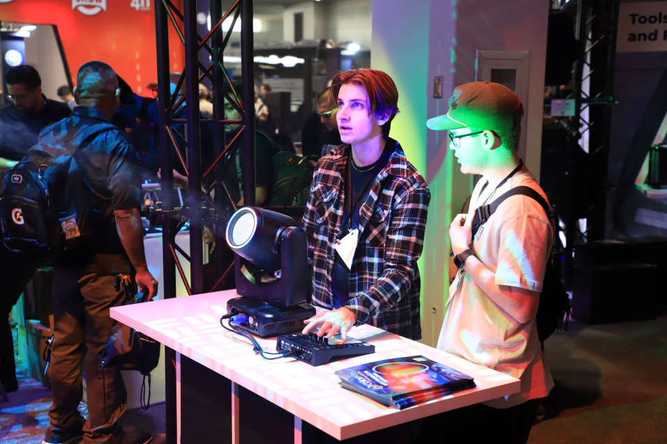 two men test a lighting product at the namm show