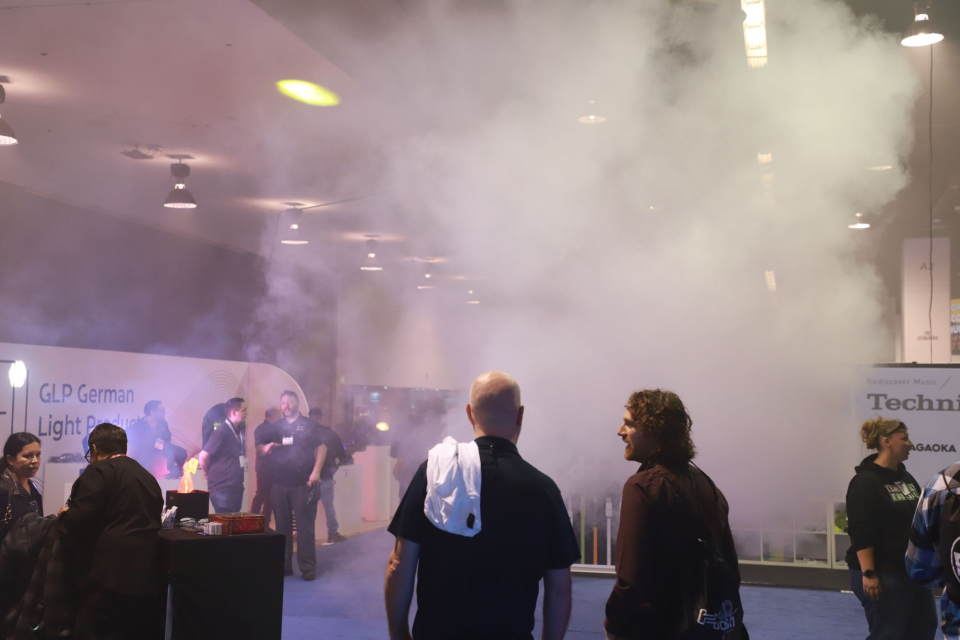 two live events professionals network as they watch a fog machine